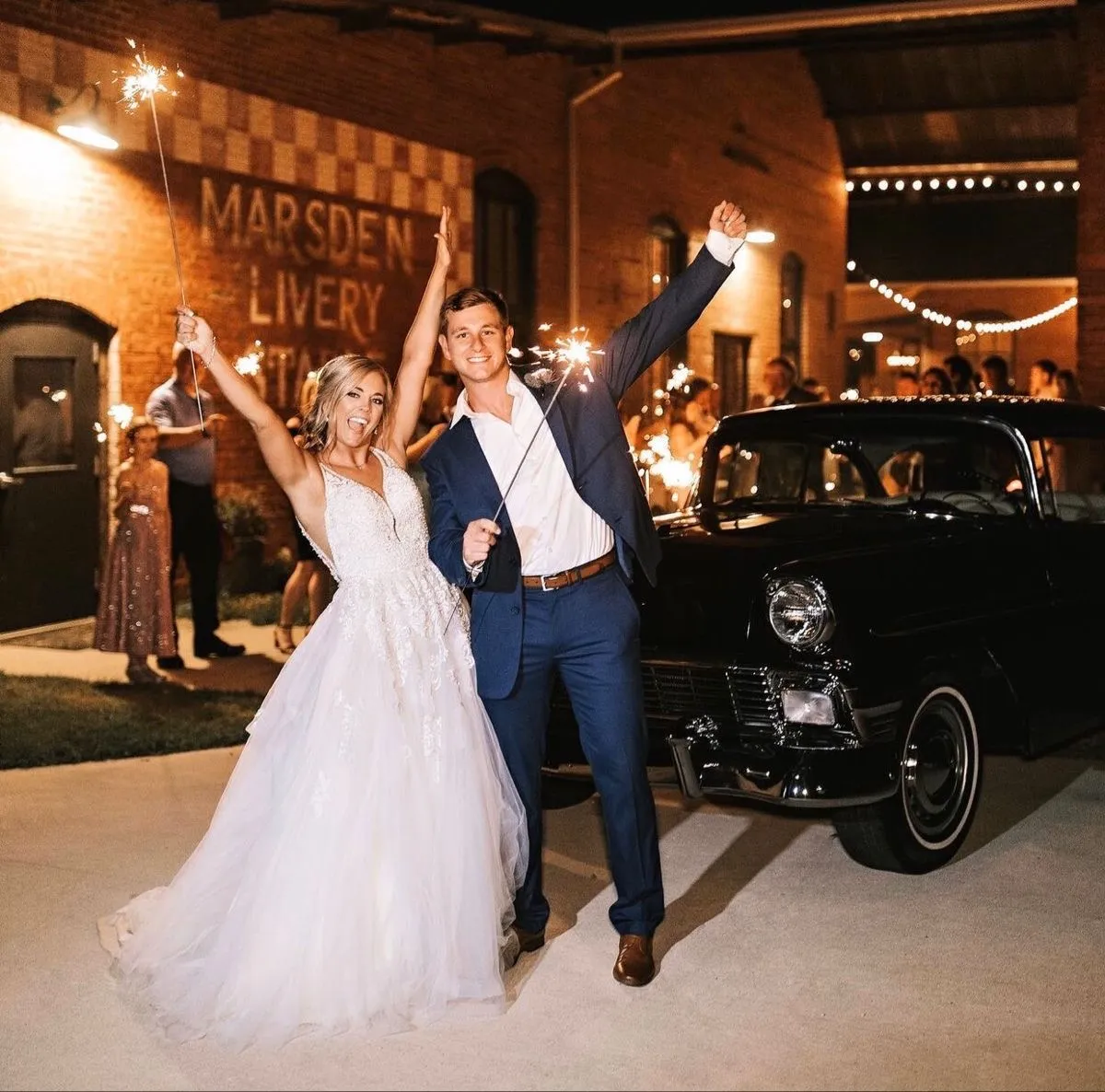 Bride and groom holding up sparklers celebrating as they leave their wedding at Empire Mills in Madison, Georgia.