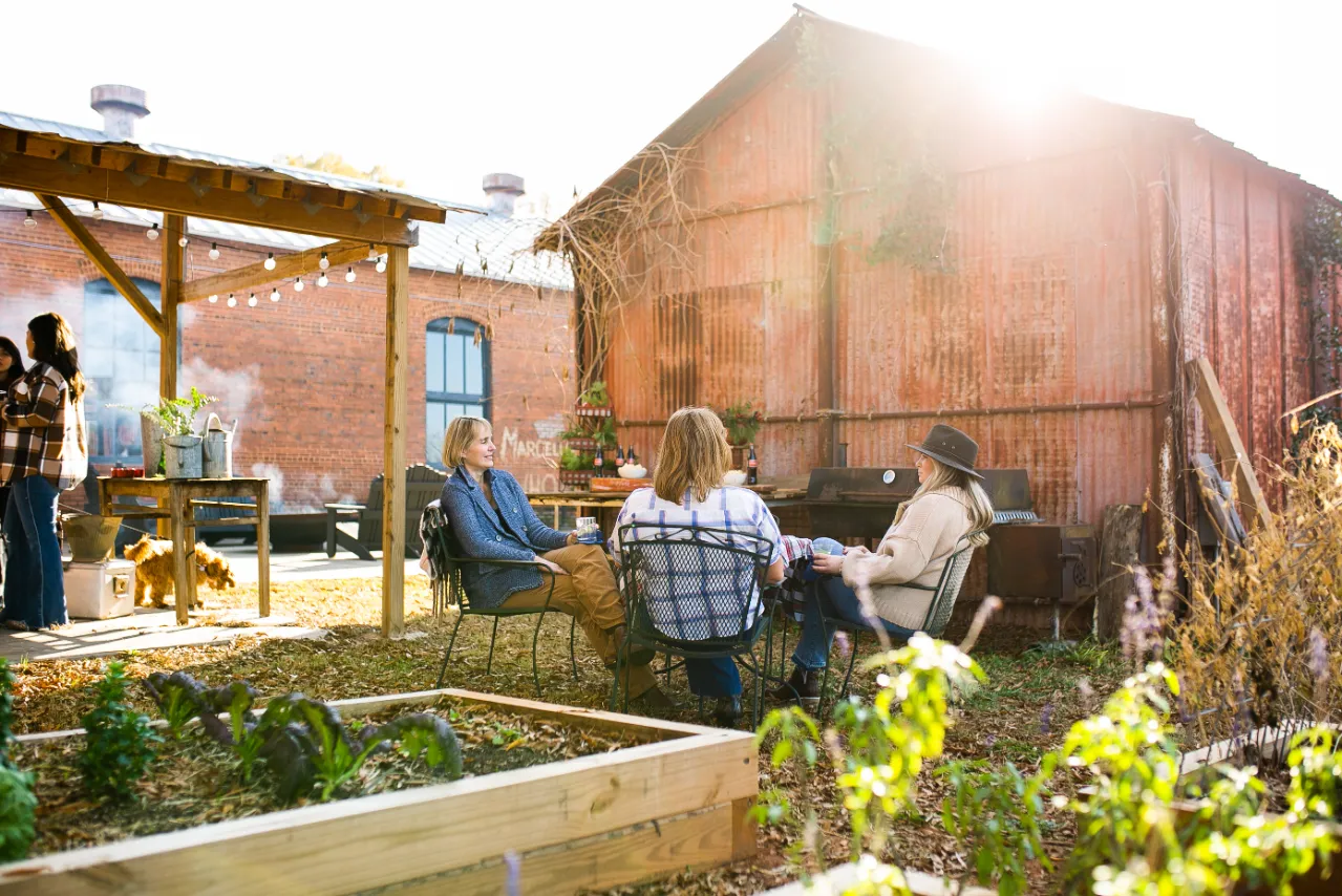 People sitting and talking and having a good time in the pasture-side courtyard at Empire Mills in Madison, Georgia.