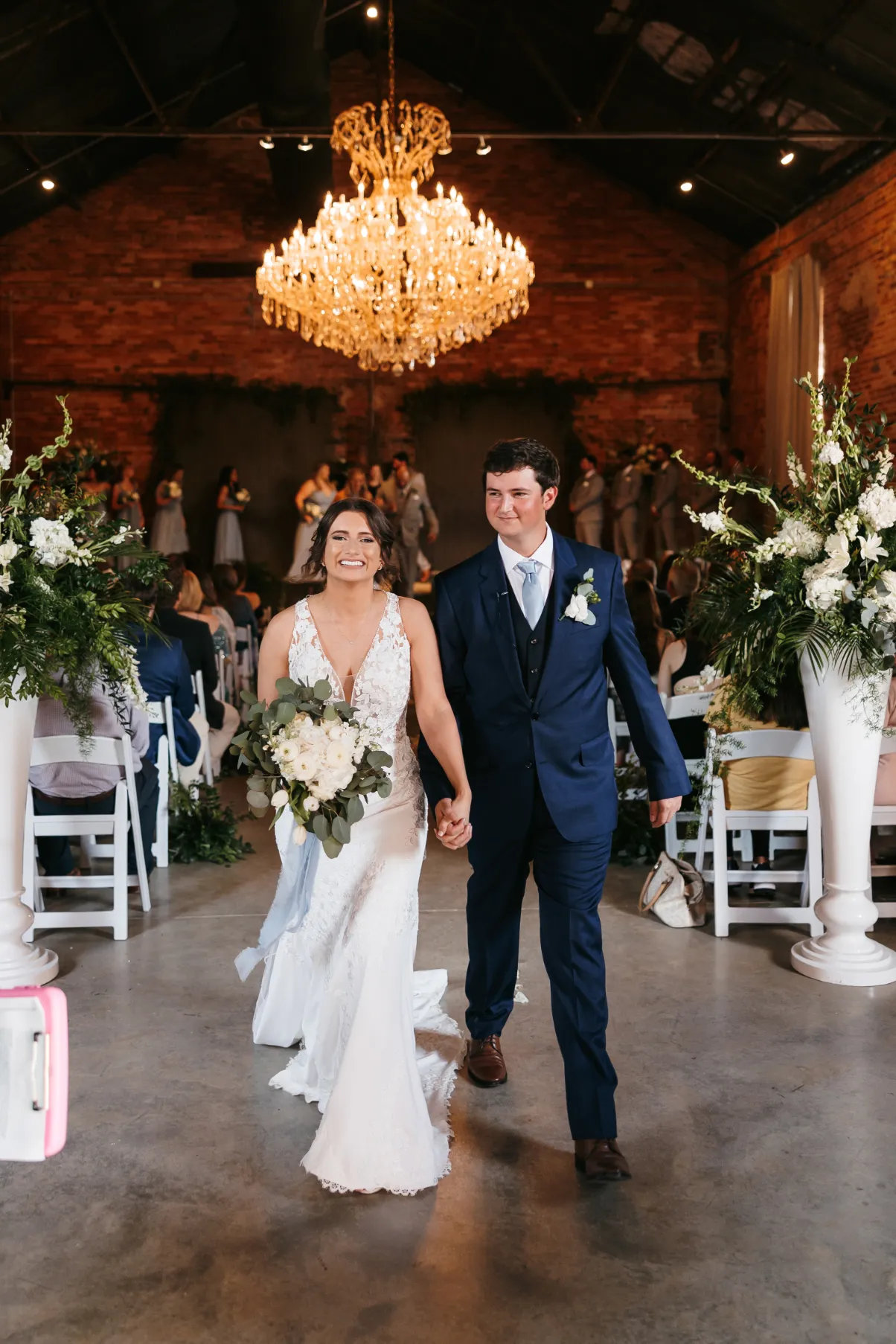 Couple walking down the aisle under an elegant chandelier in Madison, Georgia