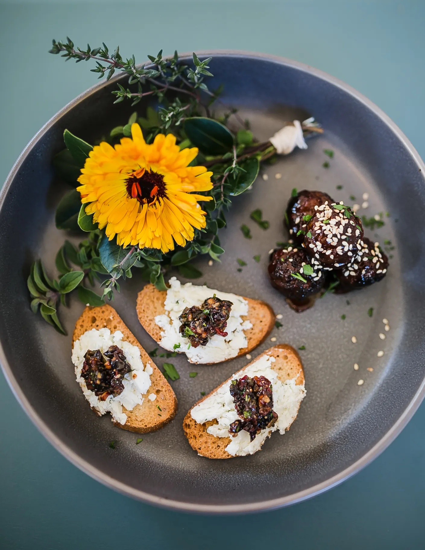 Fig walnut bruschetta appetizer displayed on a plate with fresh figs and a sunflower