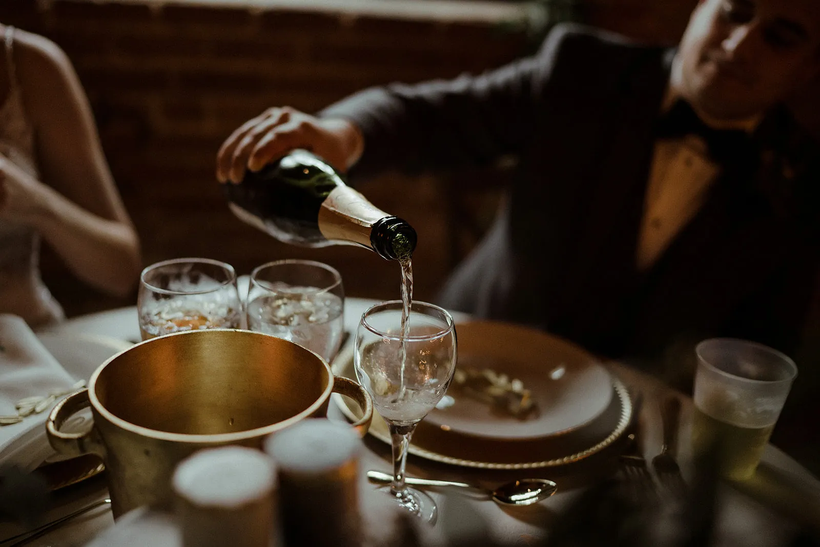 Groom at a wedding pouring champagne into a glass at Empire Mills in Madison, Georgia.