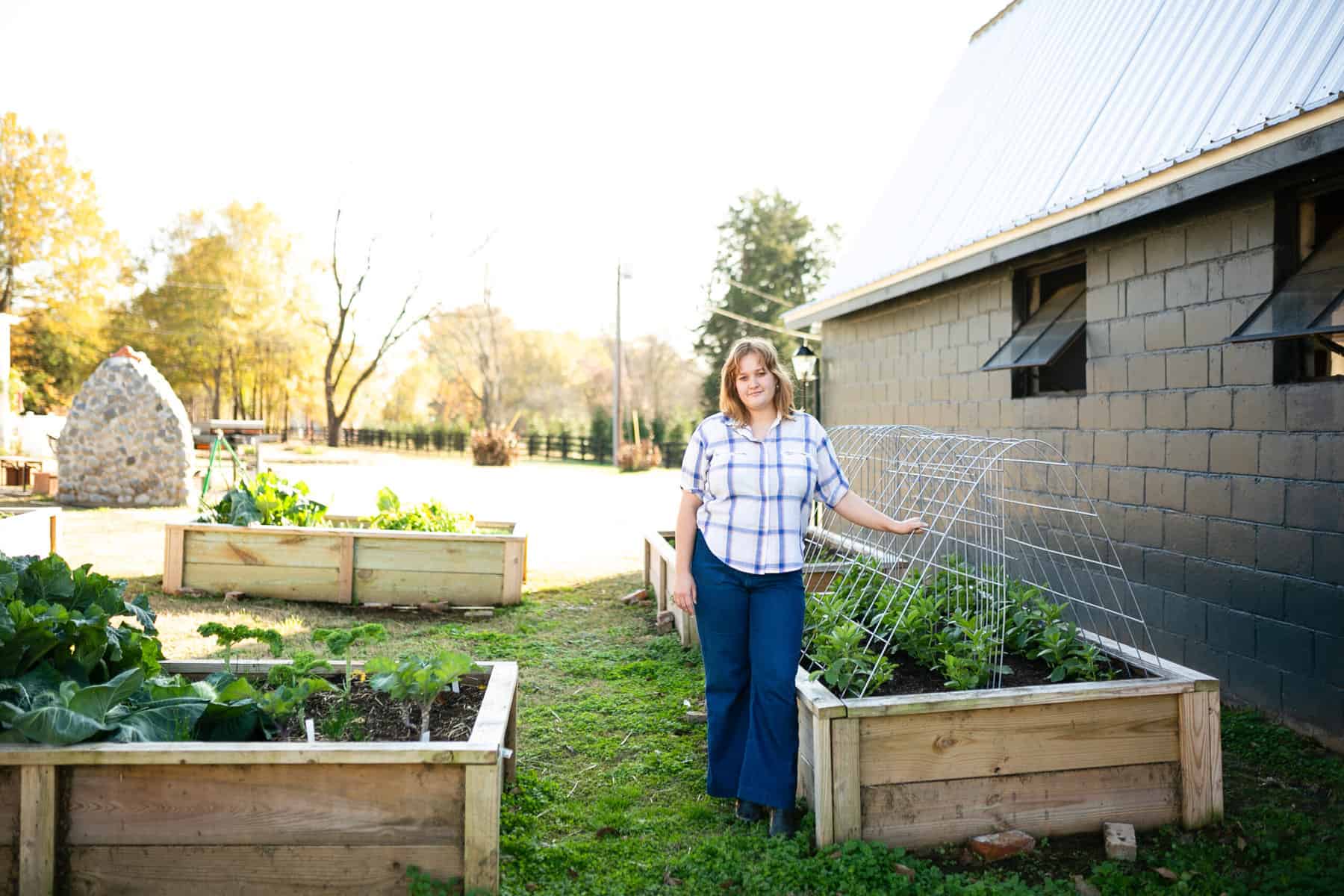 Woman standing by fresh, home-grown garden vegetables at Empire Mills in Madison, Georgia.